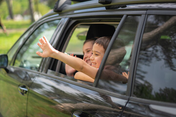 Excited Children Reaching Their Hands out of Car Window in Nature. High quality photo