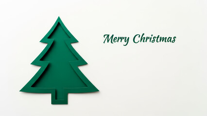 Fototapeta premium Minimalist green Christmas tree cutout with Merry Christmas greeting