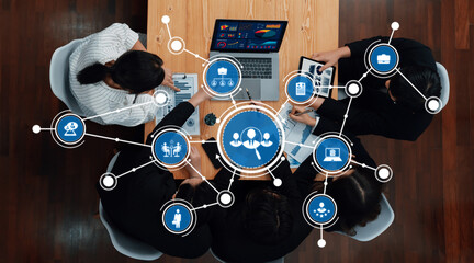 A top view of a dynamic business meeting showcasing professionals collaborating using technology to analyze data and develop innovative strategies in a modern workspace. Amity