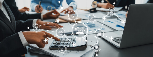 Dynamic business meeting scene highlighting financial analysis, digital symbols of connectivity, and teamwork among professionals in a modern corporate environment. Amity