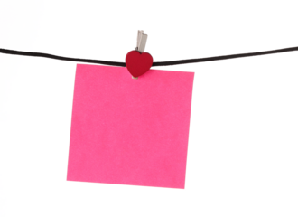 blank pink sticky note hanging on a black string isolated on white background, valentines day paper note