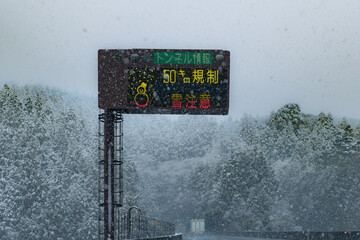 降雪の高速道路常磐道上り雪注意の電光掲示板