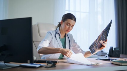 Satisfied woman radiologist studying scan clinic. Happy doctor analyzing x-ray - Powered by Adobe