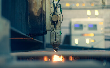 A laser machine with software cuts metal against the background of an electronic control center. A lot of glowing buttons and indicators on the laser control panel.