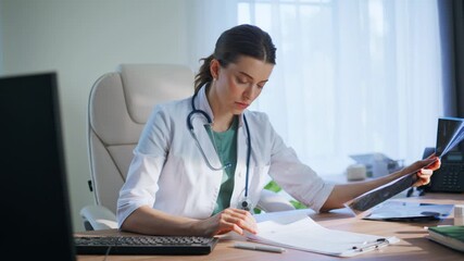 Thoughtful doctor analyzing x-ray in medical office. Closeup woman looking scan - Powered by Adobe