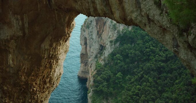 Arco Naturale rock arch framing coastal cliffs in Capri Italy during a warm summer travel day