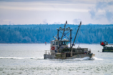 A commercial fishing boat returns to port with a load of crab pots at Westport, Washington, USA
