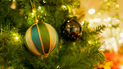 Bright and shiny Christmas toys are hanging on the Christmas tree.	
