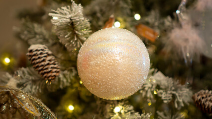 Bright and shiny Christmas toys are hanging on the Christmas tree.	

