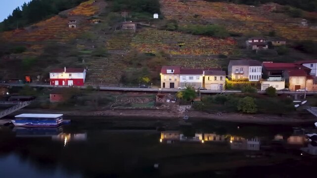 Belesar village with autumn vineyards reflecting in the tranquil mi&ntilde;o river