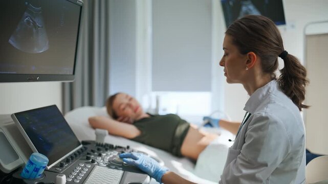 Professional examining pregnant patient with ultrasound machine clinic closeup
