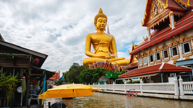 Majestic big buddha at wat paknam phasi charoen under cloudy skies in bangkok