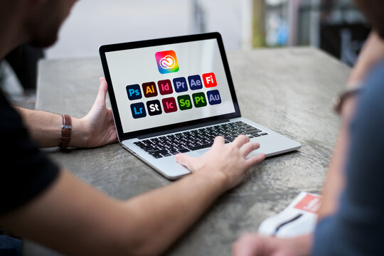 Person browsing adobe creative cloud software applications on laptop