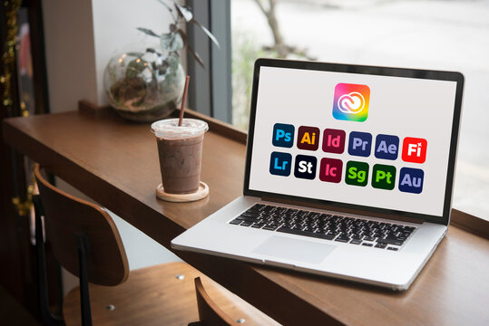 Laptop showing adobe creative cloud apps in a cafe