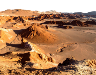 A stunning, vast, arid desert landscape under a clear, bright sky. Mountains dominate the distant horizon