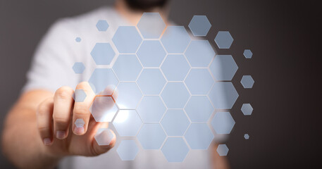Close up of a hand interacting with a virtual screen of hexagons, concept of digital technology and innovation.