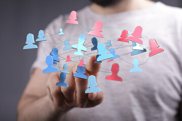 Hand reaching towards network of connected people icons, symbolizing teamwork, communication, and global connection. Digital transformation and