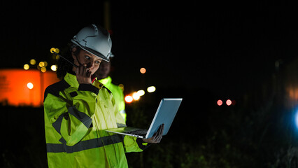 Energy professionals ensure 24 7 operations at a refinery. The team uses digital technology on a laptop to monitor sustainable production at night.