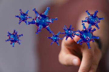 3D render of virus particles with a hand reaching out, concept of healthcare and pandemic. Visual...
