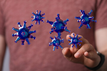 Abstract image showing conceptual representation of virus particles interacting with a human hand, highlightin