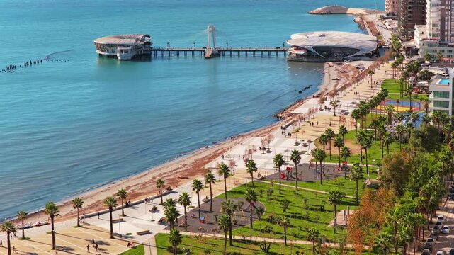Aerial drone view of the iconic circular Rotonda building extending over the turquoise waters of the Adriatic Sea in Durres, Albania