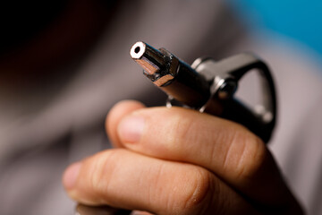 Naklejka premium Detailed shot of a person's hand with a tool nozzle. Perfect for industrial concepts and precision mechanics.