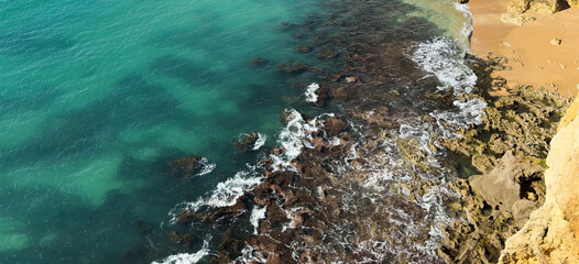 Ocean waves rolling to the rocky shore. Beautiful seascape. Aerial top view of the beautiful ocean...