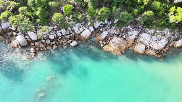 Drone View of Tropical Beach Edge with Clear Blue Sea and Rocks