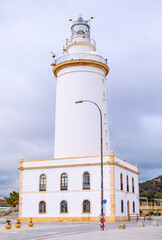 La Farola de Malaga is historic lighthouse at entrance to port, one of few Spanish lighthouses with feminine name. 19th-century beacon has guided ships for over 200 years and is beloved symbol of city