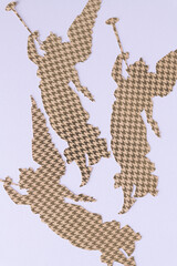 three decorative paper silhouettes of angels on blank pink paper