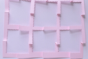 crimped pink paper square grid with perforated edges on blank paper