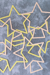 abstract star shape outlines machine-cut from pink and yellow paper and layered on paper with star pattern