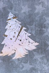 holiday tree with decorative pattern machine-cut from scrapbooking paper arranged on navy blue paper with star pattern