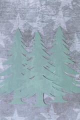 three stylized machine-cut paper trees on paper with stars