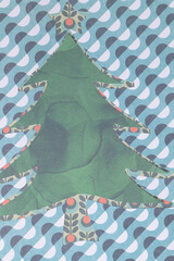 abstracted stylized holiday tree machine-cut from various papers with pattern on a bold contemporary background