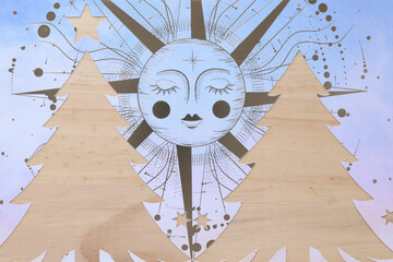 abstract stencil cutout with stylized holiday trees machine-cut from scrapbooking paper with decorative sun on wood