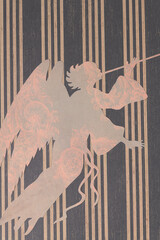 trumpeting angel machine-cut from decorative floral paper placed on a crafting sheet with stripes