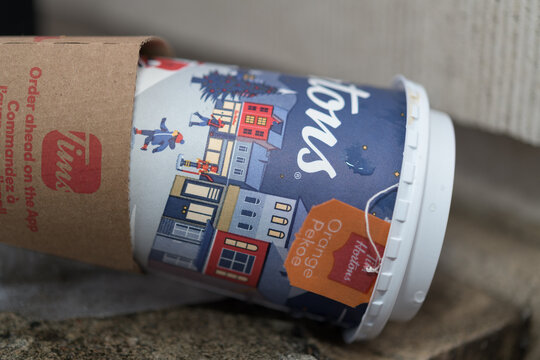 discarded beverage cup (tea) with holiday branding of Tim Hortons, close-up