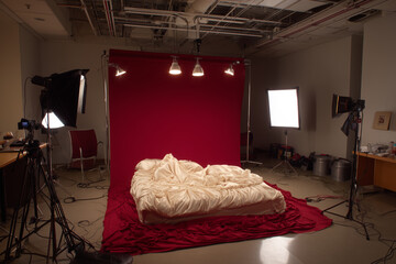Professional photography studio setup with red backdrop and softbox lights