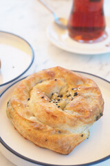 Sweet roll with black seeds on a white plate