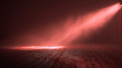 A stage with wooden floorboards dramatically illuminated by a red spotlight. The light shines from above, creating a dramatic atmosphere