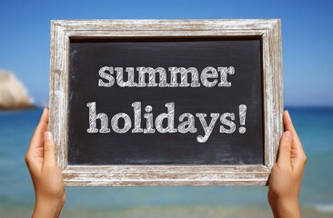 Holding Chalkboard Announcing Summer Holidays at Tropical Beach Location for Vacation and Travel Concept with Blue Sky Background.