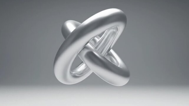 A metallic object with interconnected rings and a central triangle floats in mid-air against a gradient gray background.