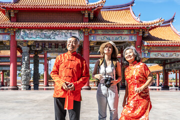Young caucasian woman traveler in lively conversation with a friendly senior couple at a stunning Chinese temple, sharing insights about nearby attractions and enjoying the vibrant cultural atmosphere