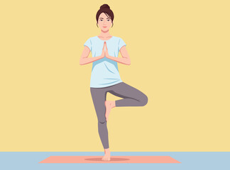 woman in a blue top and grey leggings performs the Tree Pose yoga posture on a mat