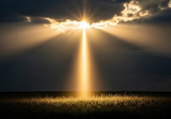 Golden light beam pierces dramatic clouds illuminating a grassy field below