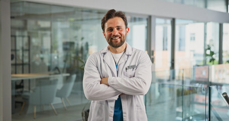 Fototapeta premium Portrait, smile and doctor with arms crossed in hospital for career pride, about us and medical service. Happy, man or job ambition for healthcare assistance, patient care and confidence for wellness