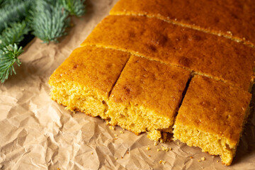 Baked cake base with fir branches on parchment paper. Selective focus.