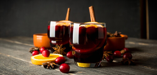 Mulled wine with ingredients on rustic wooden background. Selective focus.