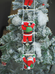 Santa Claus toy close-up on the background of a blurred Christmas tree